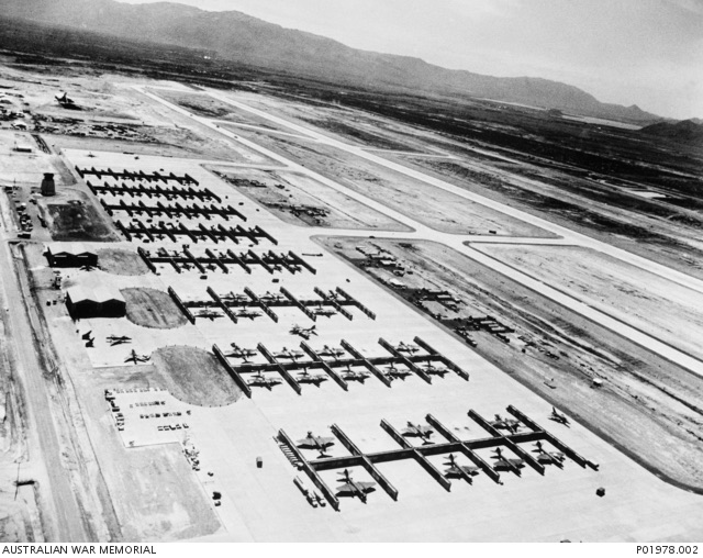 Aerial view of rows of aircraft revetments at Phan Rang air base, with runways and hills beyond.