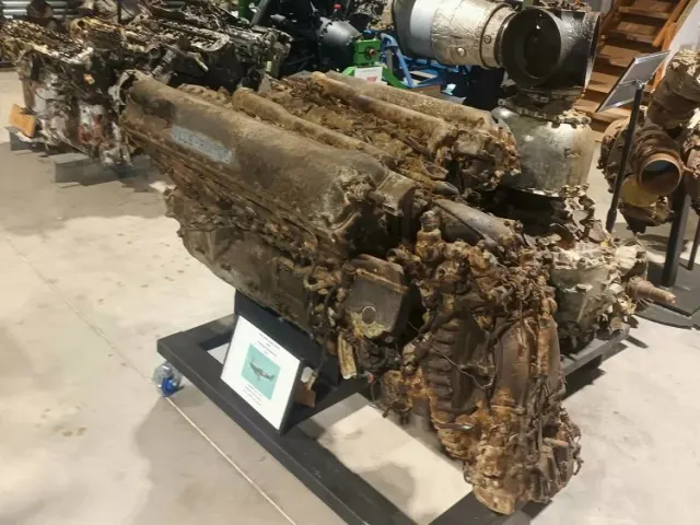 Corroded piston aero engines on display stands inside the museum shed