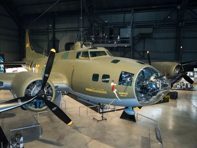 The olive-drab B-17F Memphis Belle, with her nose art, on display in a large museum hangar