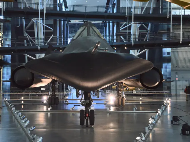 Head-on view of a black Lockheed SR-71 Blackbird on the hangar floor, with its wide chined fuselage and two engine nacelles