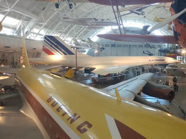 Yellow and brown Boeing 367-80 wing and fuselage in the foreground with an Air France Concorde and other airliners behind