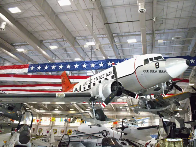 White and orange twin-engined transport aircraft on skis below a large stars-and-stripes banner
