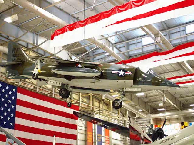 Camouflaged Harrier jump jet suspended in front of a large American flag