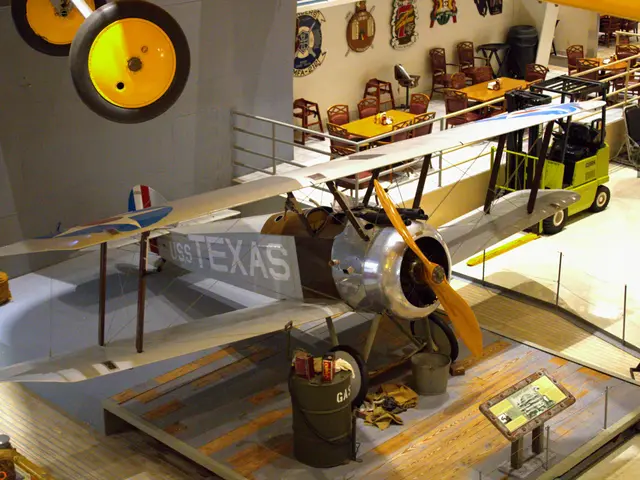 Silver and wooden First World War biplane on a raised wooden platform marked Texas