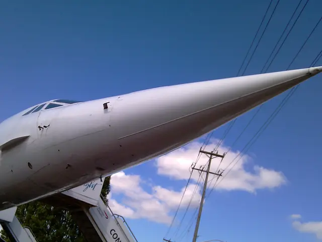 Low view of Concorde's pointed nose and cockpit windows with boarding stairs behind
